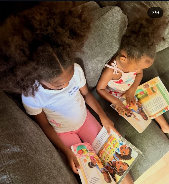 Aria and Selah reading the book together on the couch