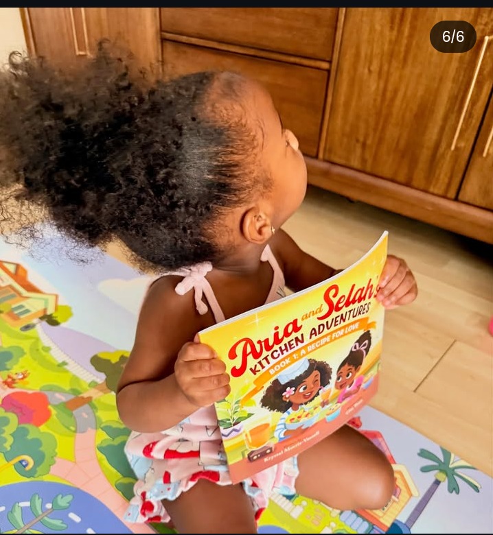 A toddler holding up A Recipe for Love